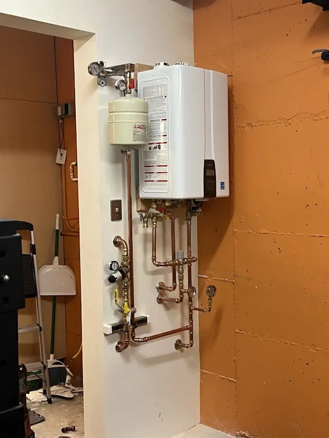 Plumbing technician inspecting water heater connections in Forney
